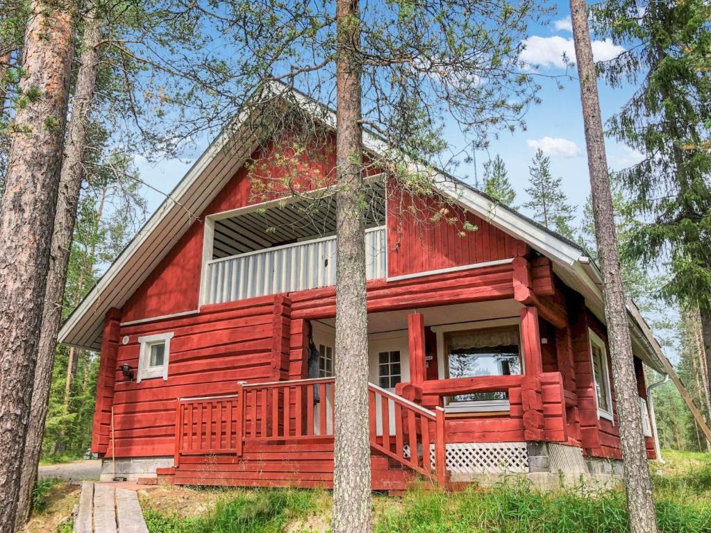 a red cabin in the woods with trees at Holiday Home Pajalan hirsitupa by Interhome in Nissi