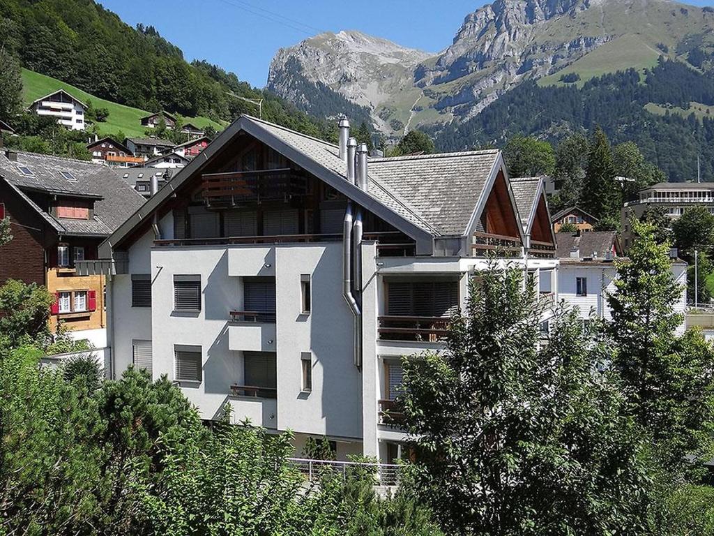 a large white building with a mountain in the background at Apartment Seelenmattli by Interhome in Engelberg