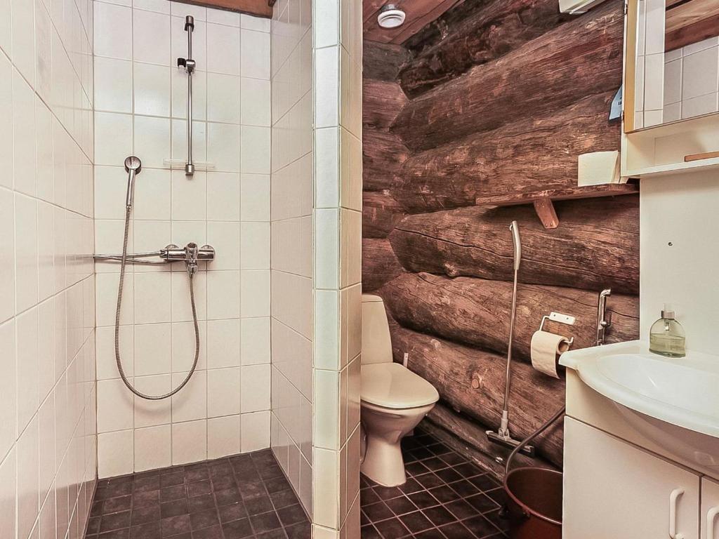 a bathroom with a toilet and a wooden wall at Holiday Home Luostonseita 3 by Interhome in Luosto
