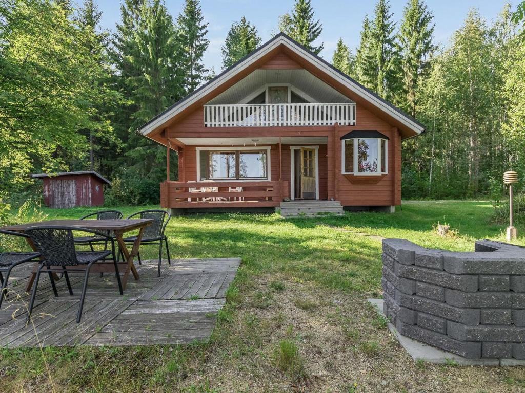 Cabaña de madera con mesa y sillas en el patio en Holiday Home 6440 by Interhome, en Pihlajaniemi