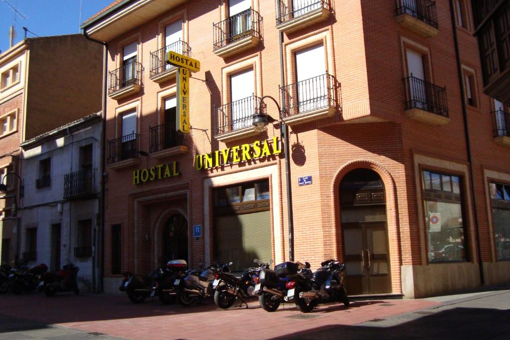 um grupo de motociclos estacionados em frente a um edifício em Hostal Universal em Benavente