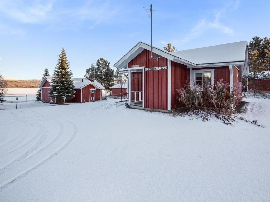 a red barn in the snow with a driveway at Holiday Home Nutukas-ylläksen lapikas by Interhome in Äkäslompolo