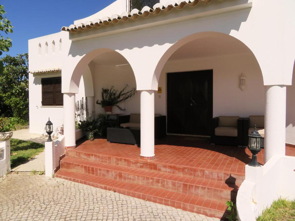 a white and red brick building with a white door at Villa Alcaide in Portimão