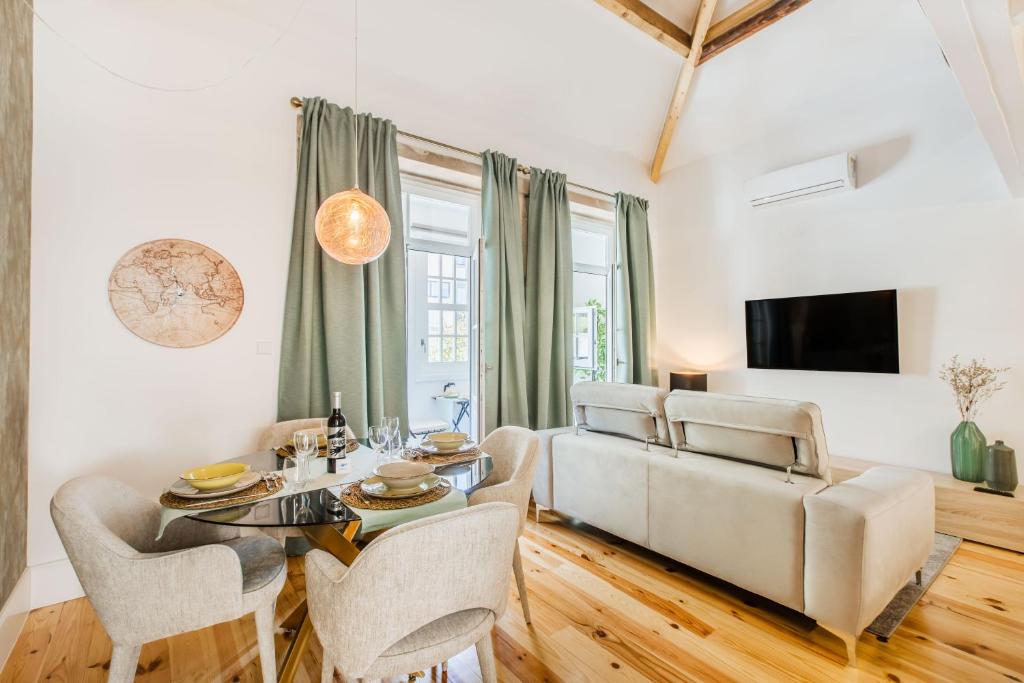 uma sala de estar com uma mesa e um sofá em Santa Catarina Charming Loft no Porto