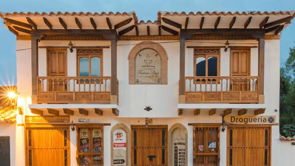 a building with a store front with wooden doors at Fontana Plaza Hotel in Villa de Leyva