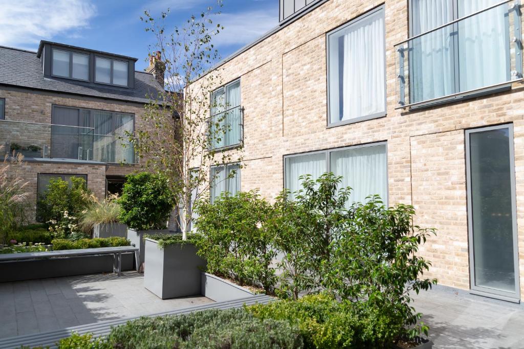 ein Backsteingebäude mit Pflanzen davor in der Unterkunft Citystay - Midsummer Mews in Cambridge