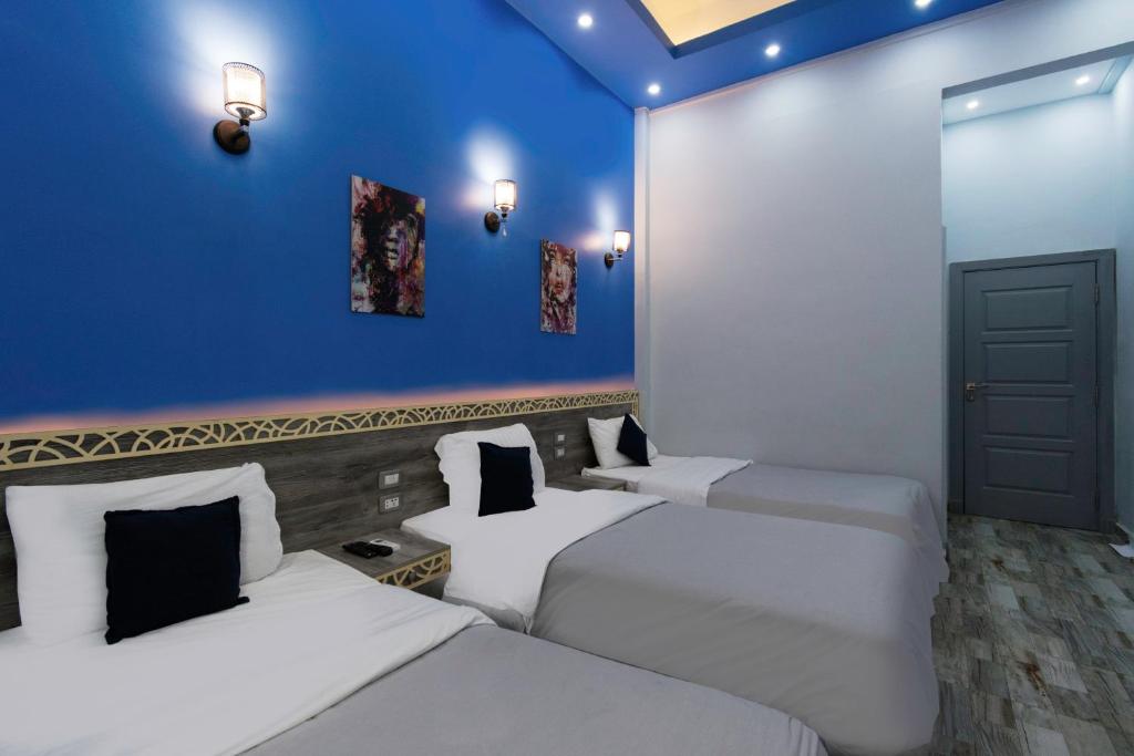 two beds in a room with a blue wall at Australian Deluxe Hostel in Cairo