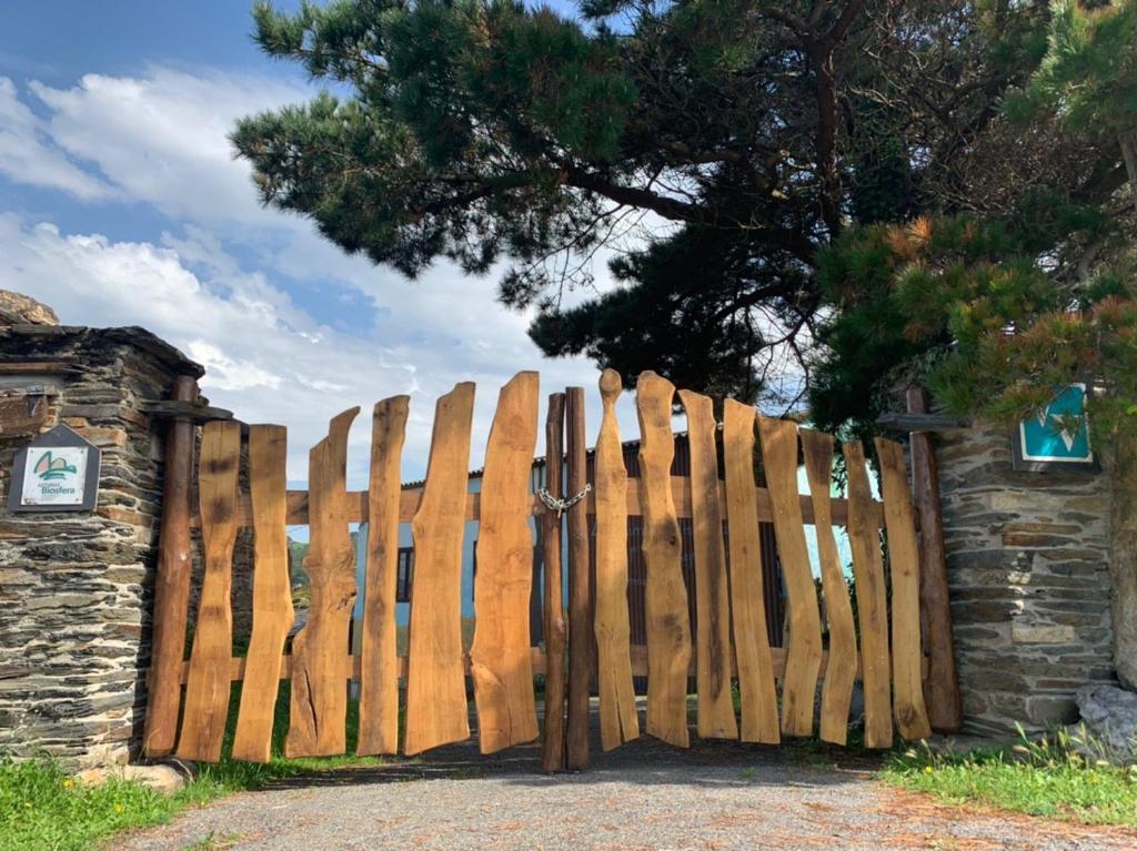 a wooden gate in front of a stone wall at Vivienda Vacacional Bioxana in Molejón