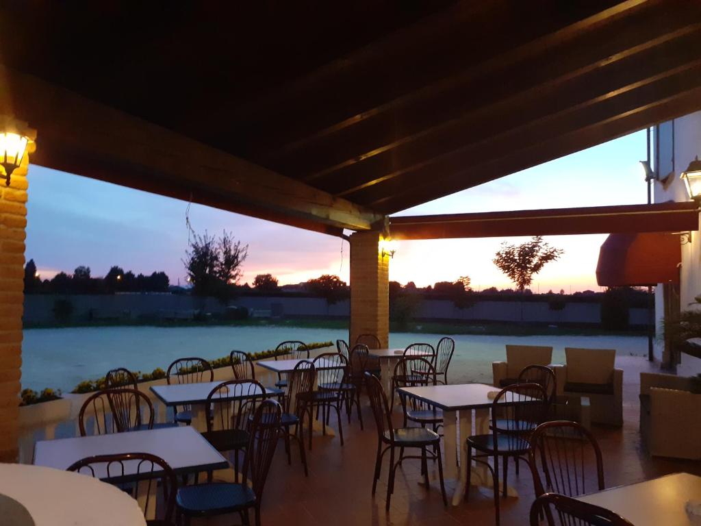 un patio vuoto con tavoli e sedie al tramonto di La Locanda dei Gagliardi a Lugo