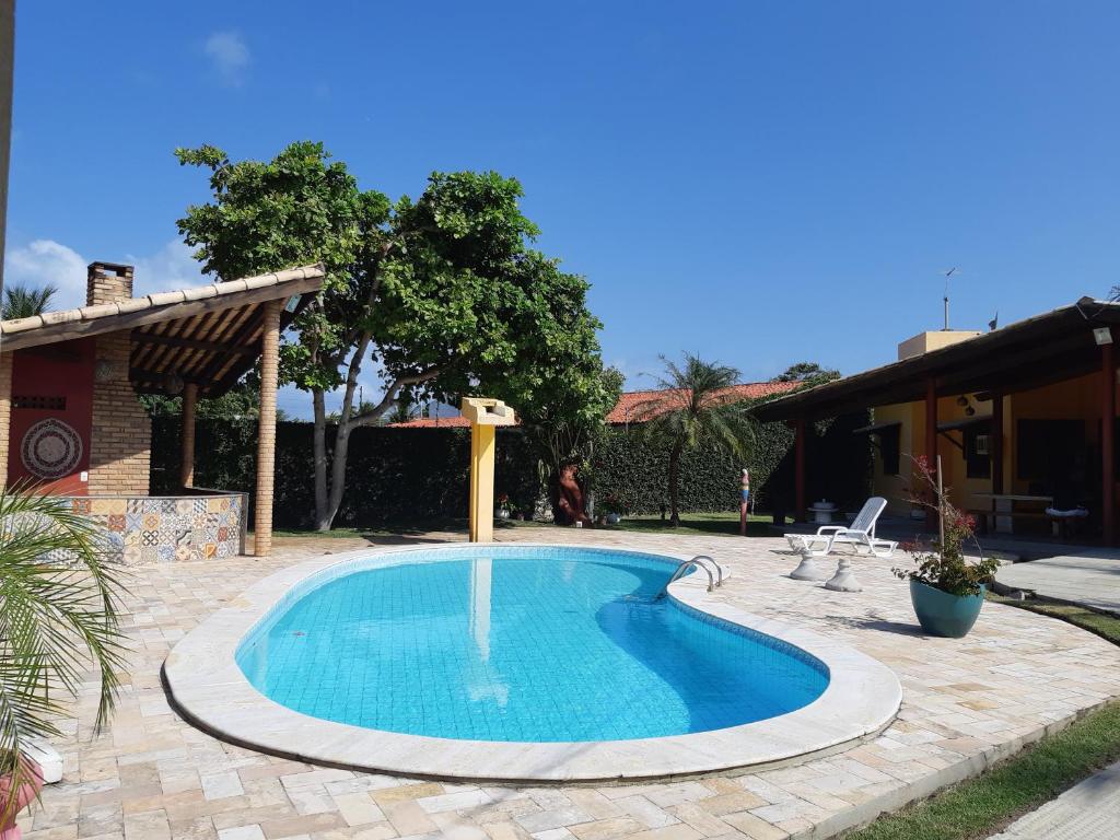 a small swimming pool in a yard with a house at PARAISO NAS ÁGUAS in Barra de São Miguel