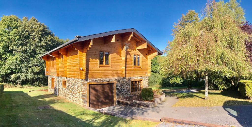 a log house with a garage in a yard at Chalet de Charme in Rochehaut