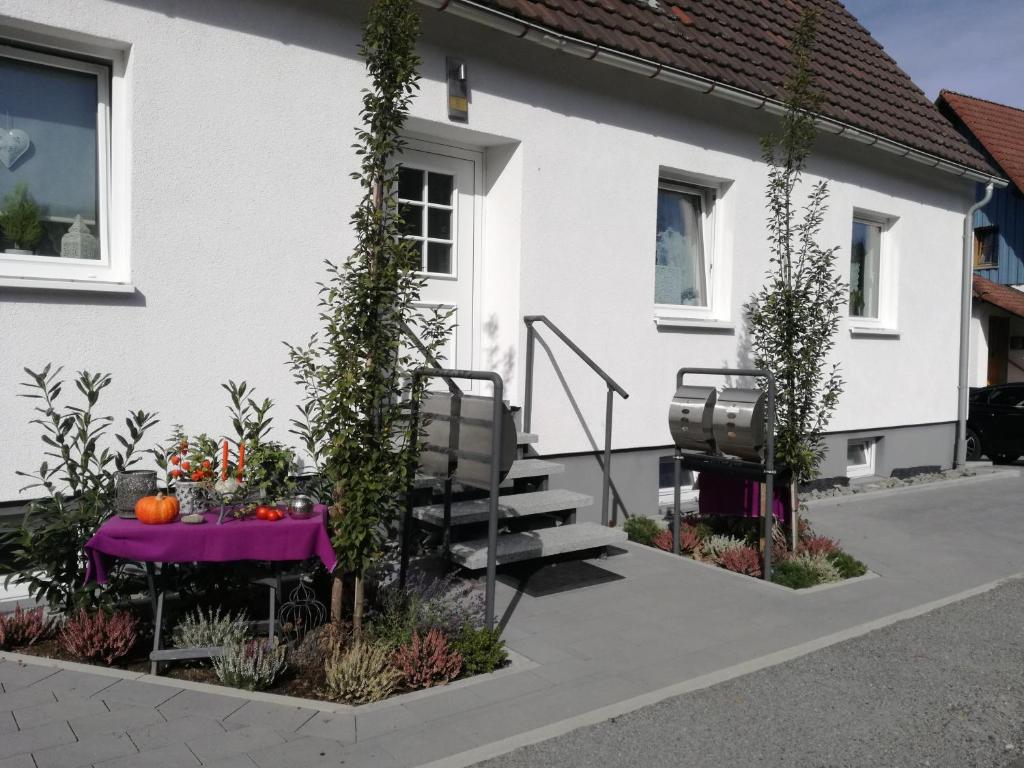 a table with a purple table cloth in front of a house at Ferienwohnung Nitsche in Bad Laasphe