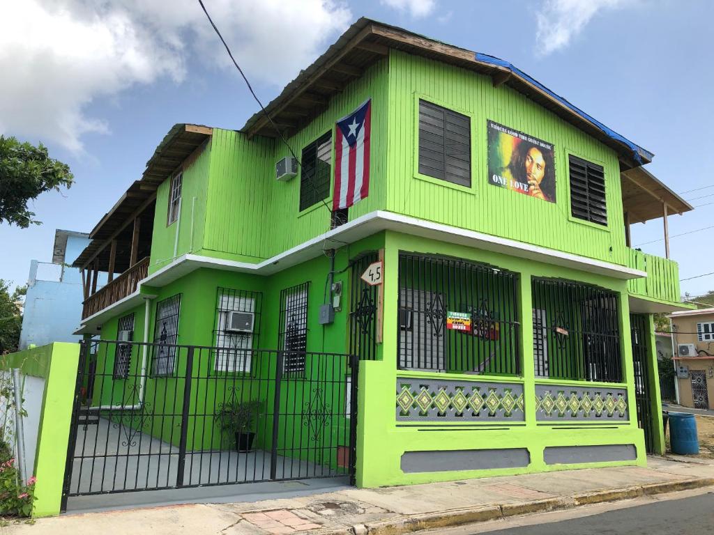 un edificio verde lima con una puerta negra en Vieques Good Vibe Guest House, en Vieques