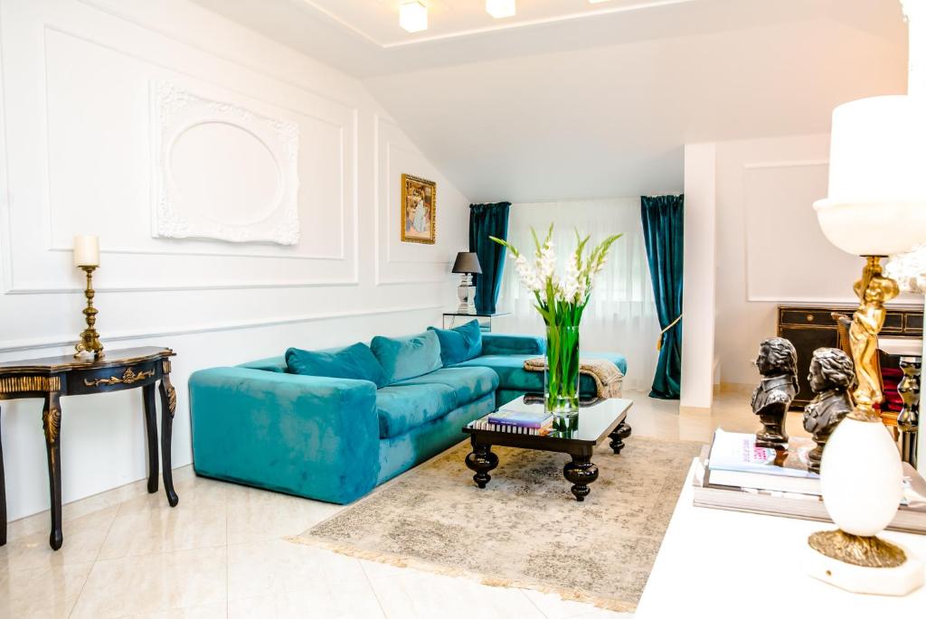 ein Wohnzimmer mit einem blauen Sofa und einem Tisch in der Unterkunft Medziotoju Apartments in Palanga