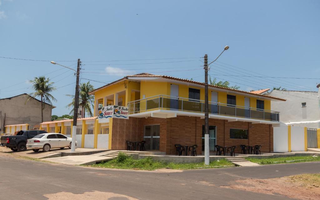 a yellow building on the side of a street at Suítes Soure in Soure