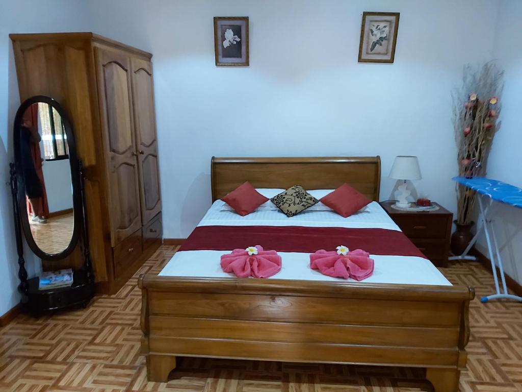 a bedroom with a bed with two pink towels on it at Morry's Apartment in Baie Sainte Anne