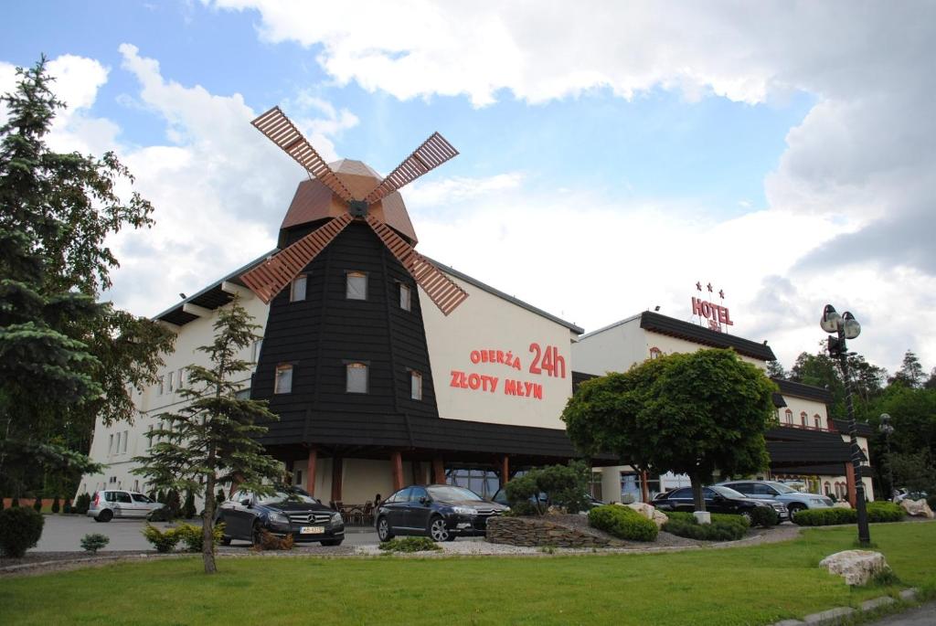 um moinho de vento na lateral de um edifício em Hotel Złoty Młyn Polichno em Polichno