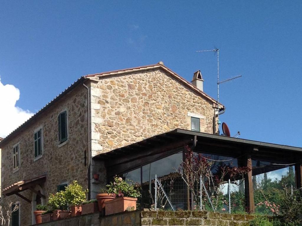 a brick house with potted plants in front of it at CASA LORY Poggio Murella in Poggio Murella