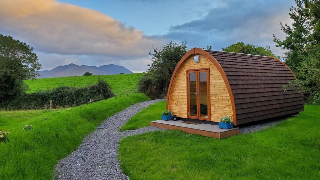 a small cabin in the middle of a grassy field at Farmyard Lane Glamping in Killarney