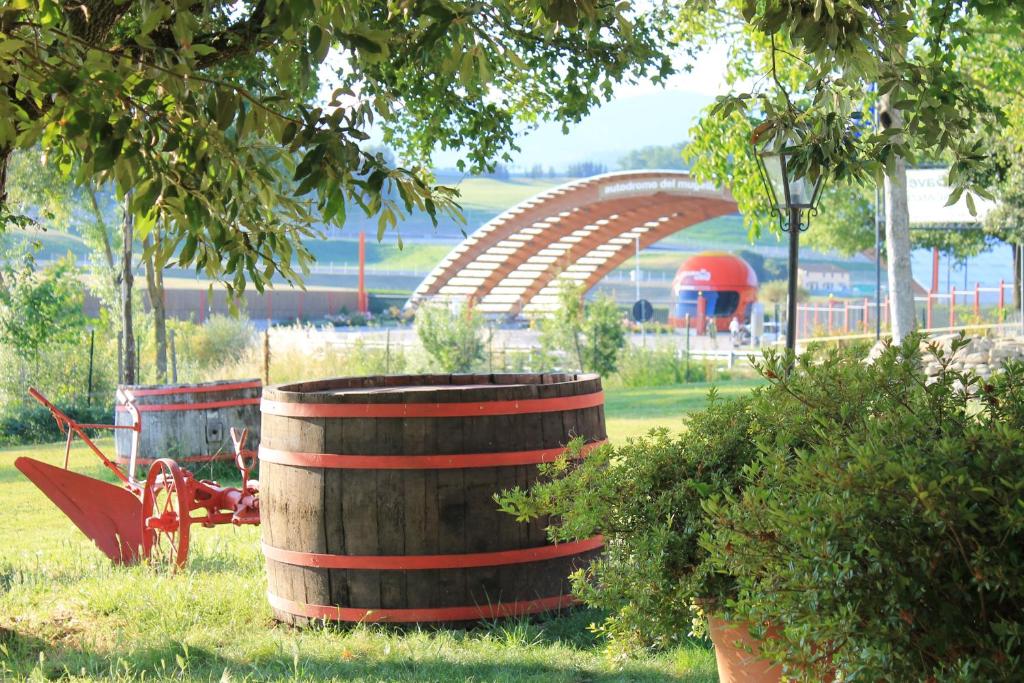 a wooden barrel in a park with a roller coaster at Poggio Savelli in Scarperia