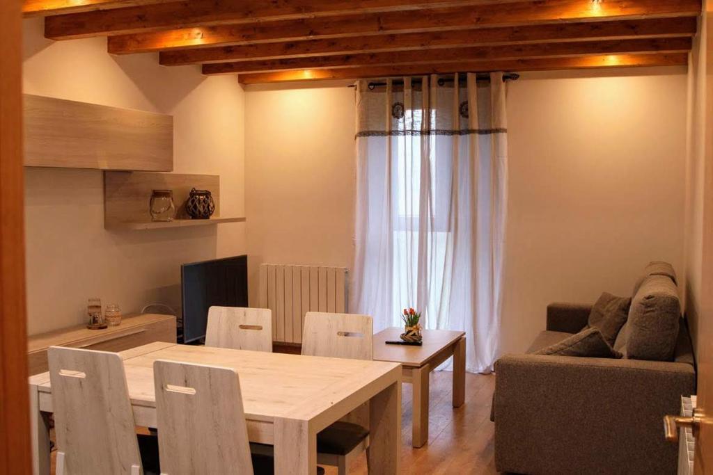 a living room with a wooden table and a couch at Apartamentos Zabalarena Ola in Orbaiceta