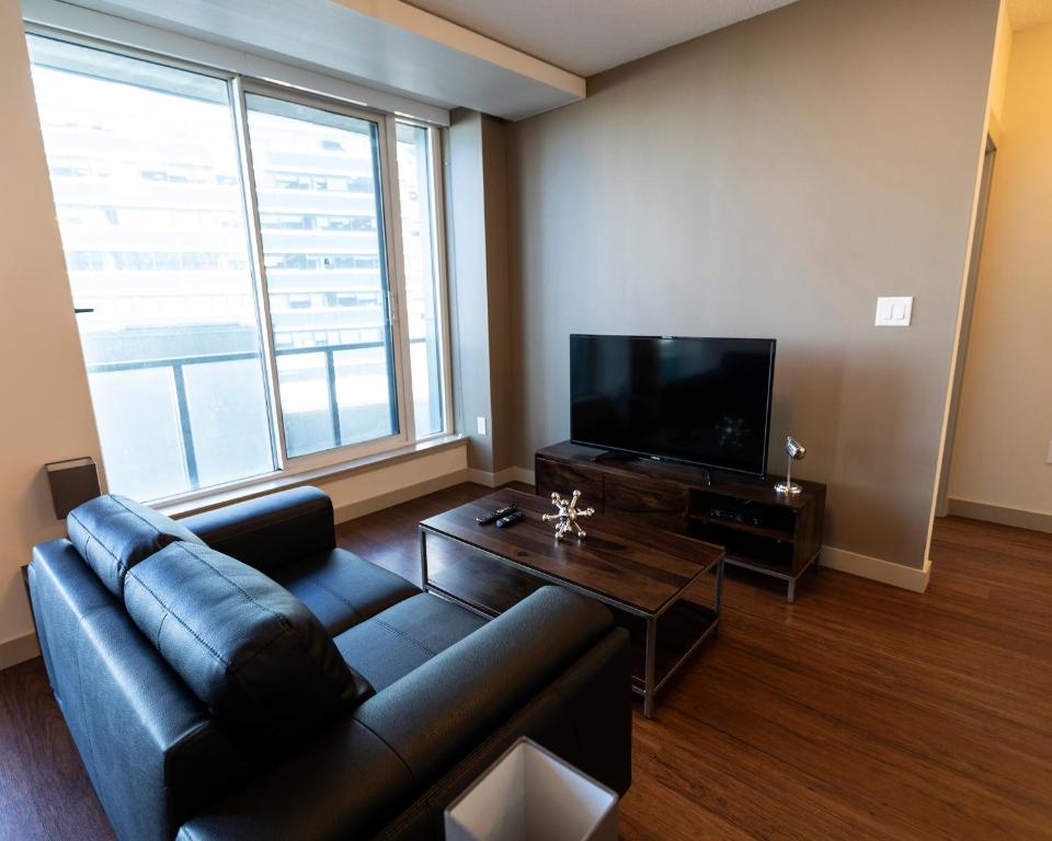 salon z kanapą i telewizorem w obiekcie Mayfair by Corporate Stays w mieście Edmonton