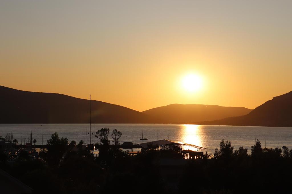a sunset over a body of water with mountains at Boka Bay in Tivat