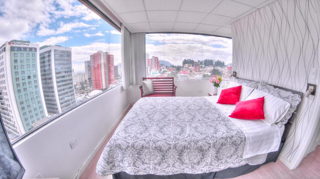 1 dormitorio con cama y ventana grande en Executive Suite, en Quito