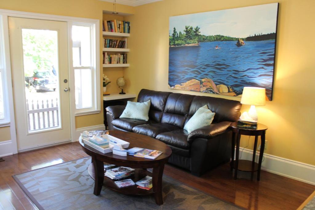 a living room with a leather couch and a table at The Novel Stay in Halifax
