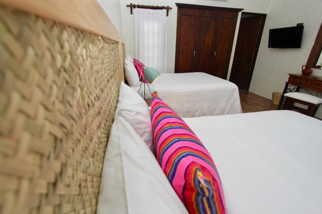 a hotel room with two beds with striped pillows at Hotel Trébol in Oaxaca City