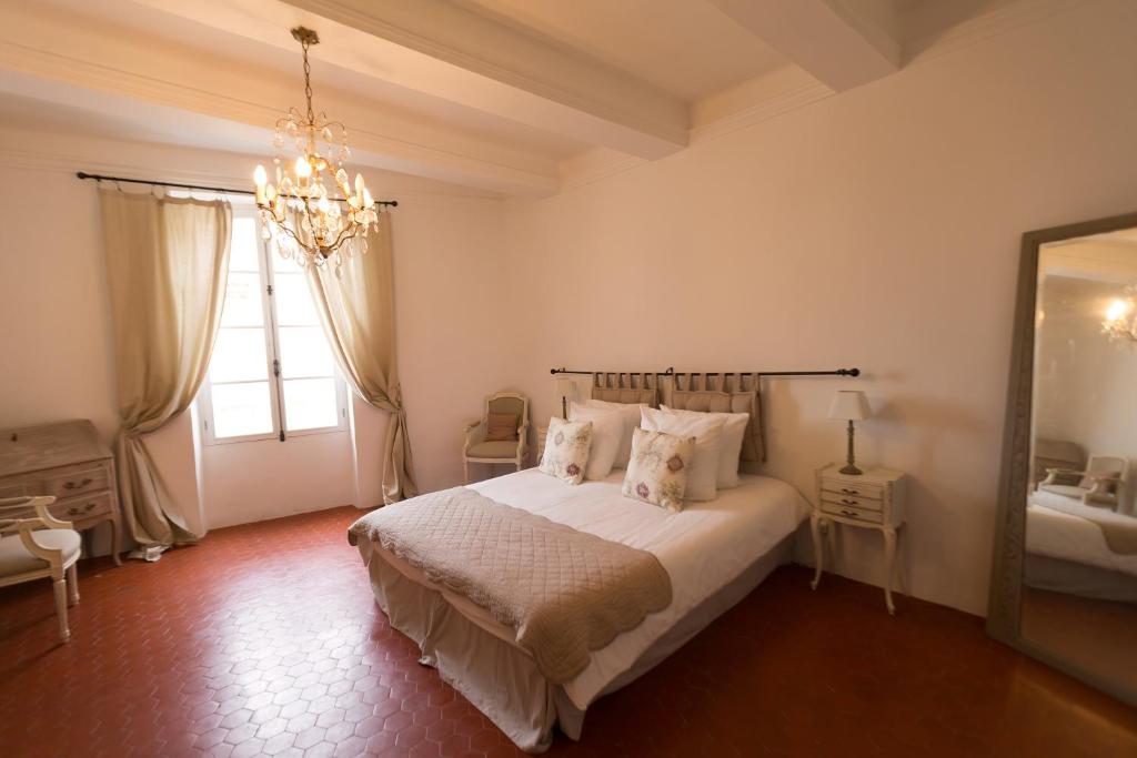 1 dormitorio con cama y lámpara de araña en Les Chambres De Charlotte, en Cucuron