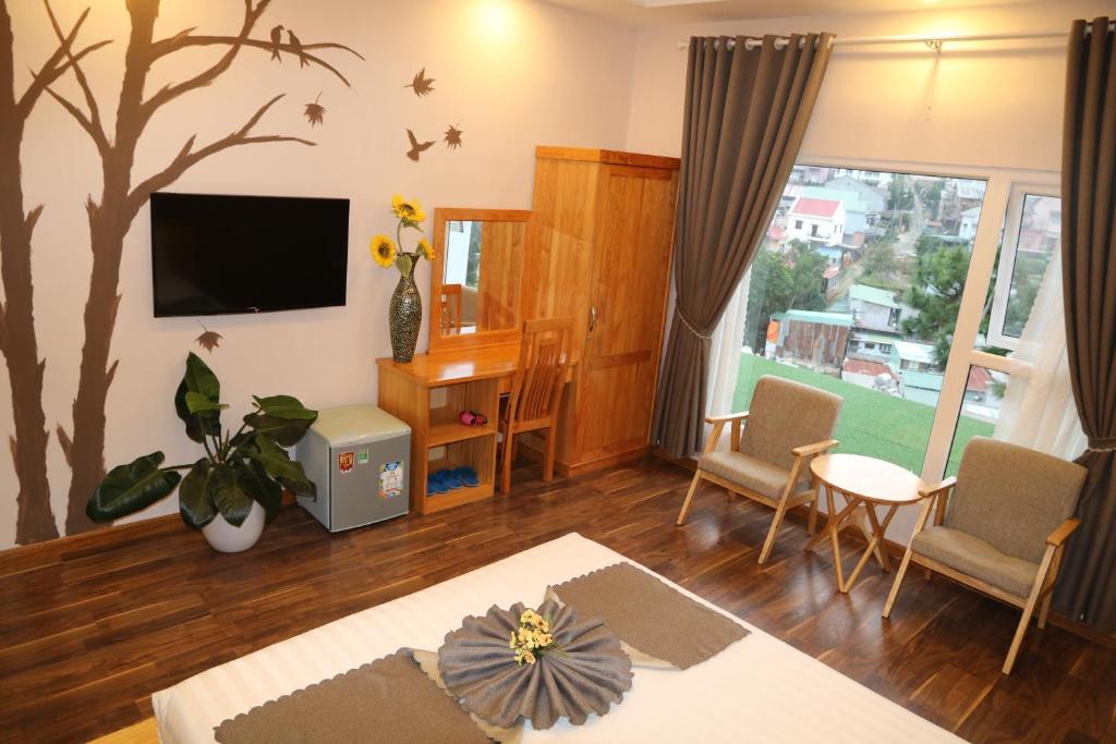 un soggiorno con murale sull'albero di Redhouse Dalat Hotel a Da Lat