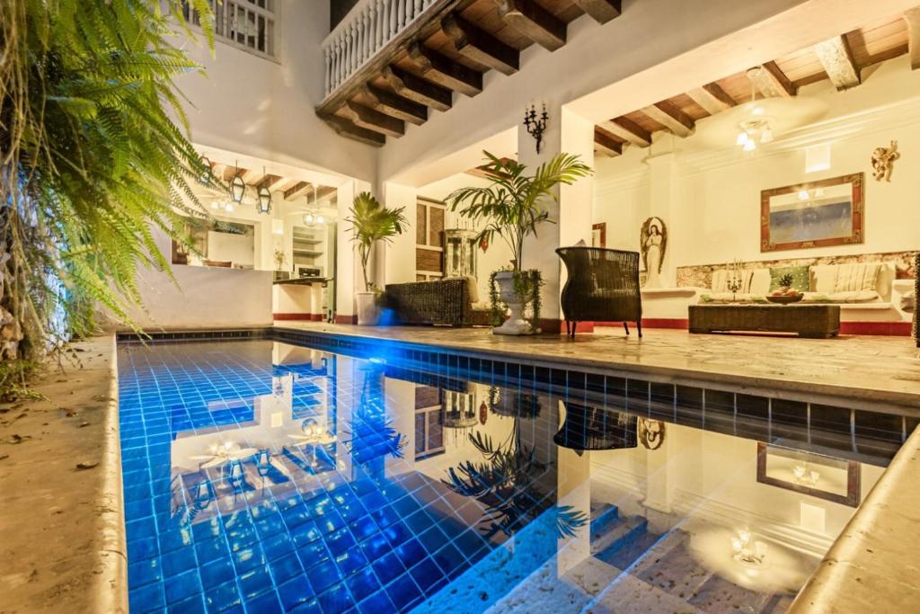 a swimming pool in a house with a blue tile floor at Hotel Casa la Tablada in Cartagena de Indias
