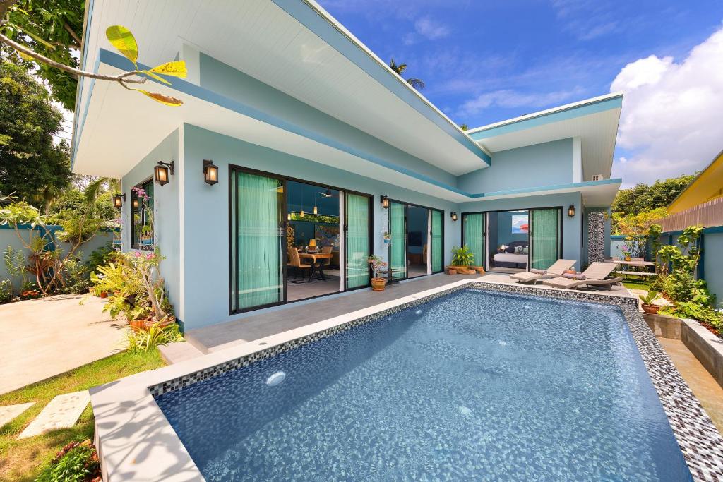a villa with a swimming pool and a house at Villa Baan Suaan Kluay Mai in Laem Sor