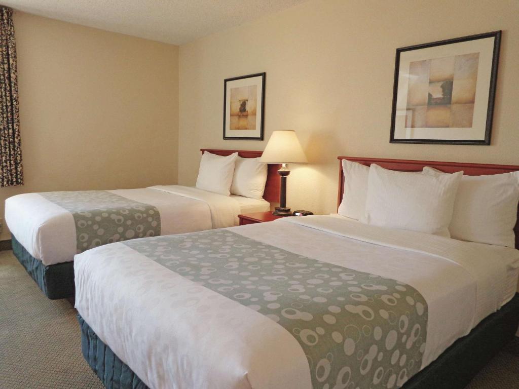 um quarto de hotel com duas camas e duas lâmpadas em La Quinta by Wyndham Albuquerque Journal Ctr NW em Albuquerque