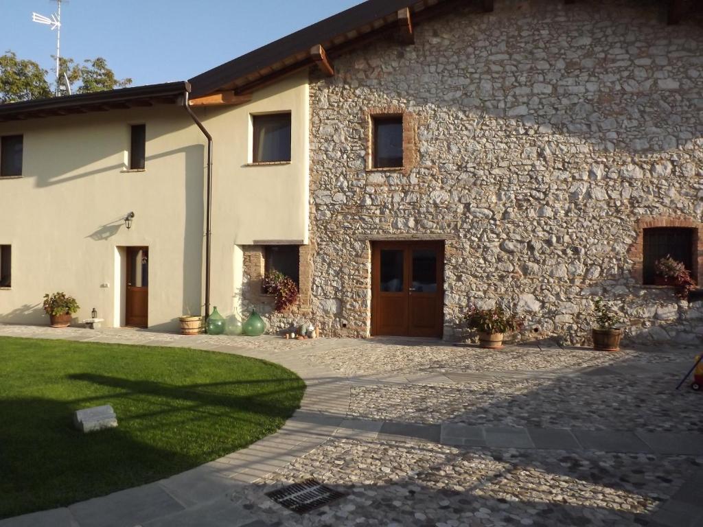 een groot stenen huis met een binnenplaats bij Casa della Fornace in San Vito al Torre