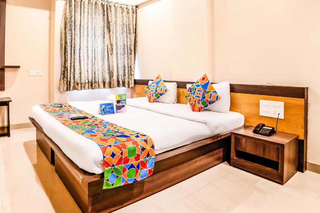 a bedroom with a bed and a table in it at FabHotel Imperio Baner in Pune