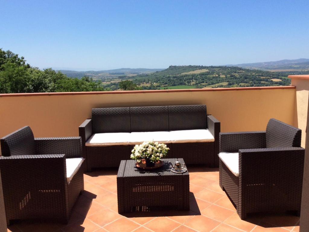 a patio with two chairs and a table with flowers at VISTA PANORAMICA SULLE TERME DI SATURNIA in Poggio Murella