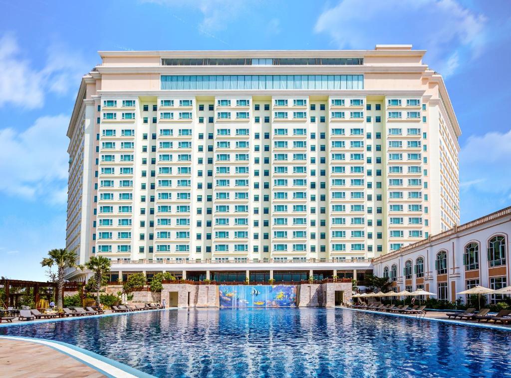 金邊的住宿－索卡金邊酒店，一座大型建筑,前面设有一个大型游泳池