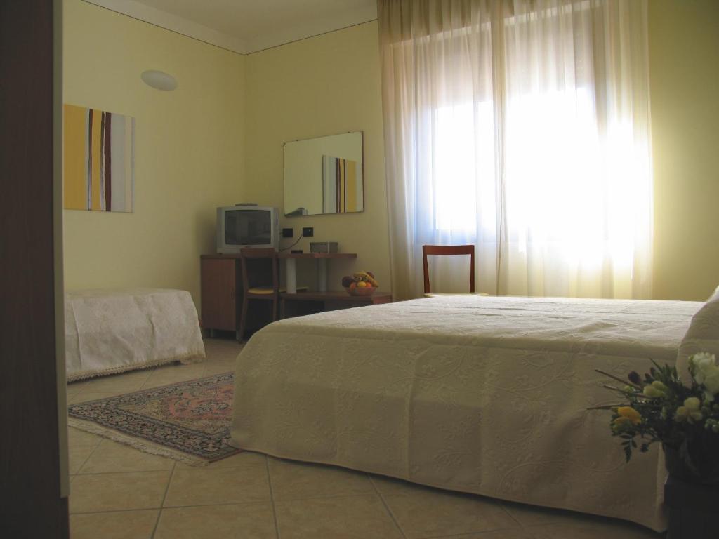 ein Schlafzimmer mit einem weißen Bett und einem Fenster in der Unterkunft Locanda dei 4 in Narni