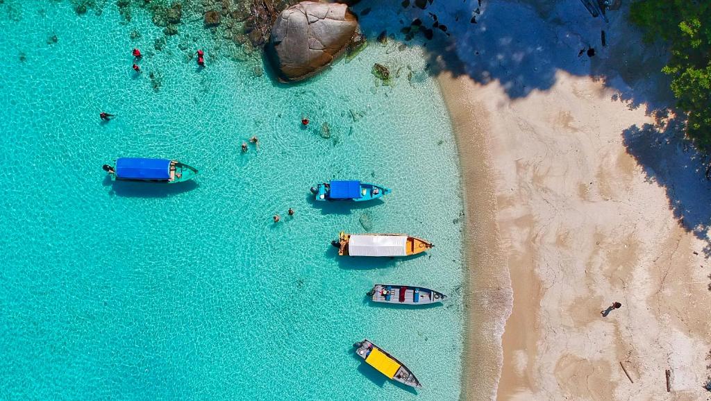 an overhead view of boats in the water on a beach at Sunyi Villas in Kuta Lombok