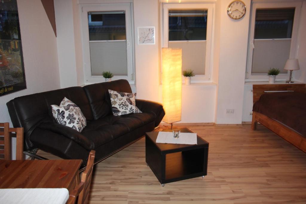 a living room with a leather couch and a coffee table at Wohnen auf Zeit In Bendorf in Bendorf