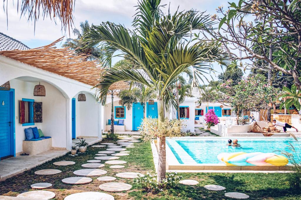 una piscina en una casa con dos personas nadando en The Koho Air Hotel, en Gili Air