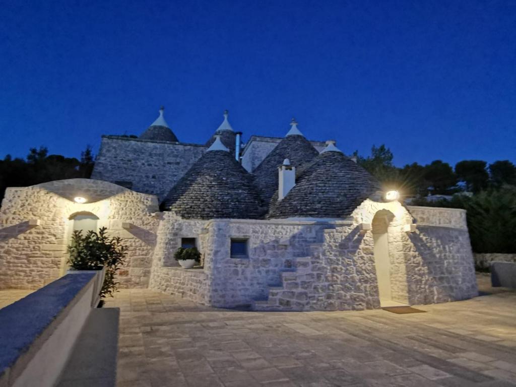 セルヴァ・ディ・ファザーノにあるTRULLI GIACI&MAURIの夜の大石造りの建物