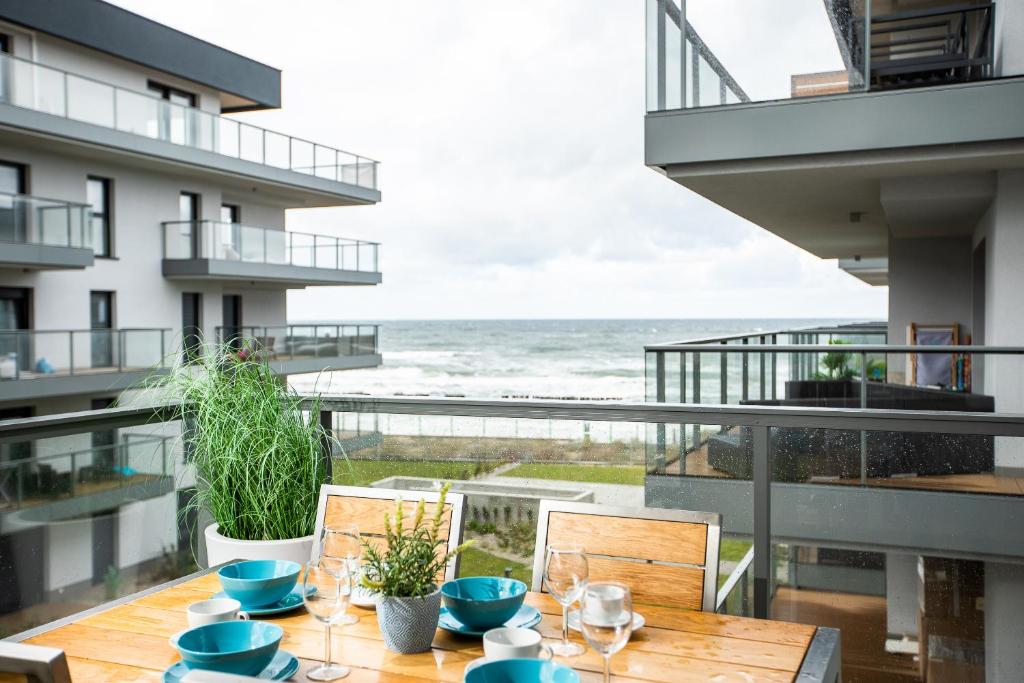 a table on a balcony with a view of the ocean at Blue Port Gardenia in Dziwnów