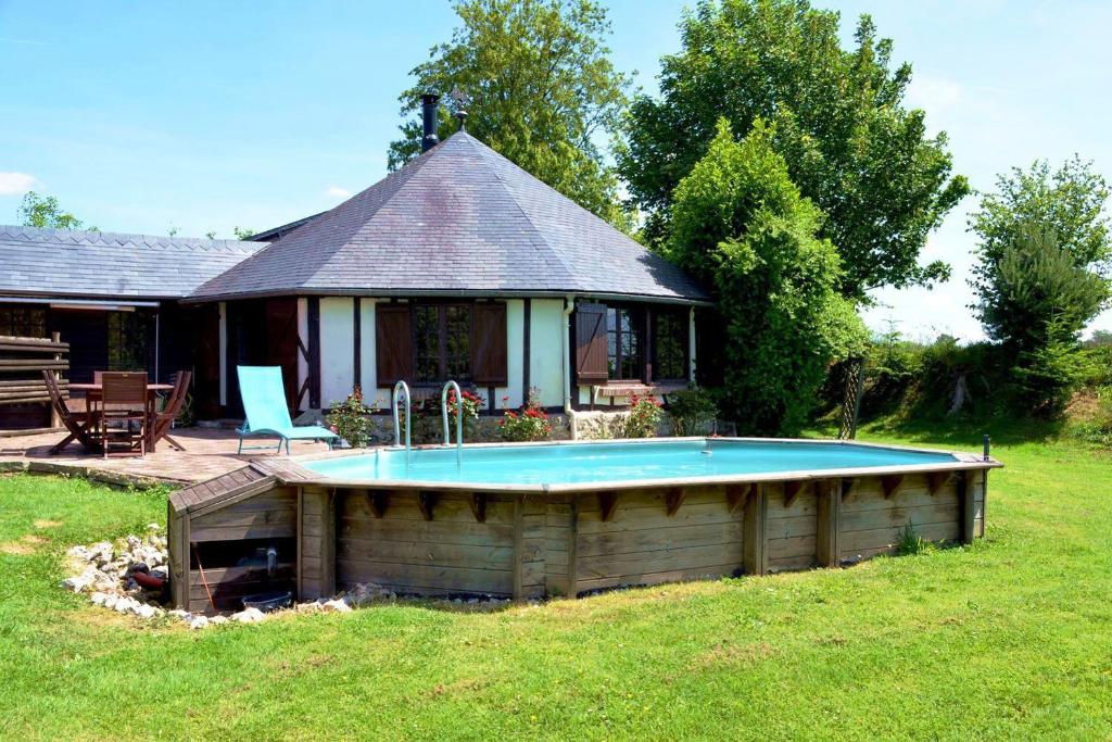une maison avec une piscine dans la cour dans l'établissement Gîte le Manège Normand, à Grand Camp