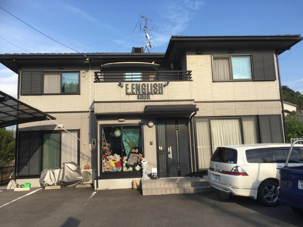 a white car parked in front of a building at E.English Guest House in Sekimachi