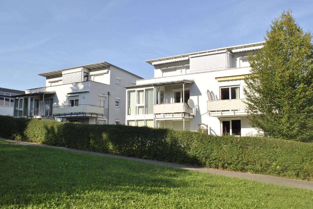 um grande edifício branco com uma sebe à sua frente em Private Wohnung Bunter Hund em Aalen