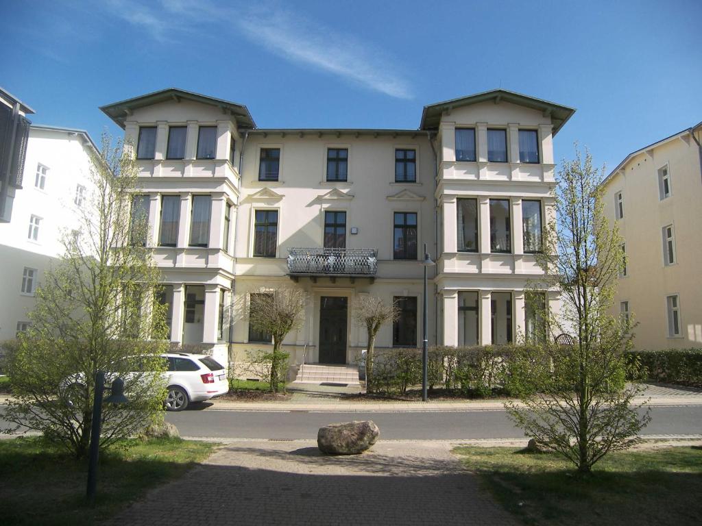 a large building with a car parked in front of it at Villa Goodewind 100 m zum Strand in Ahlbeck