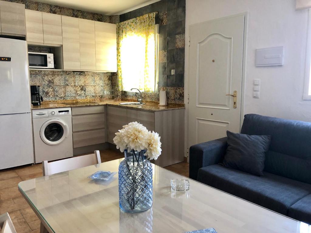 una cocina y una mesa con un jarrón de flores. en Apartamento Triana II Bolonia, Tarifa, en Bolonia
